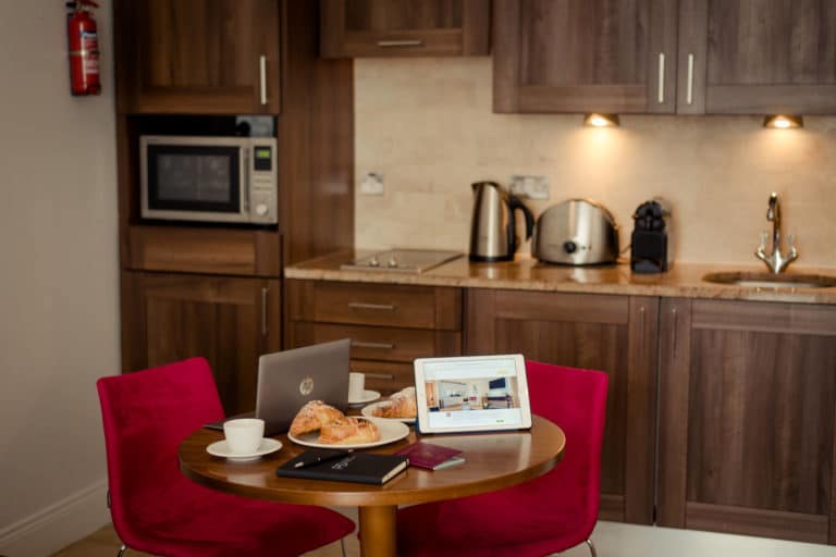 PREMIER SUITES PLUS Ontbijt in Dublin Leeson Street en laptops op keukentafel een bed