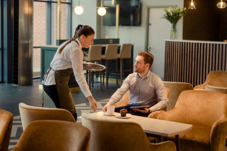 The Hoban Hotel Kilkenny staff serving coffee and pastries to guest in lobby